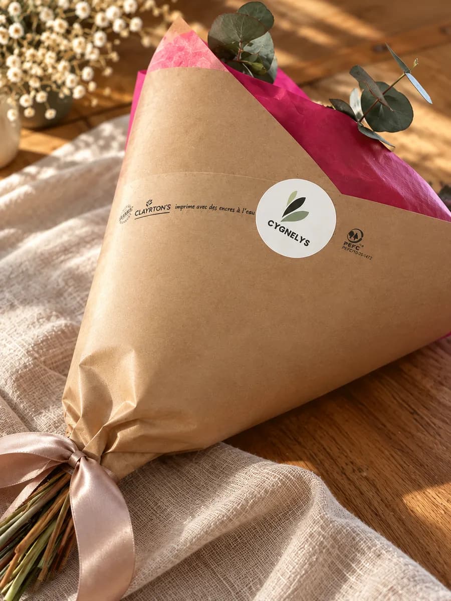 Bouquet de fleurs séchées Cygnelys emballé dans du papier kraft avec un ruban, prêt à être expédié
